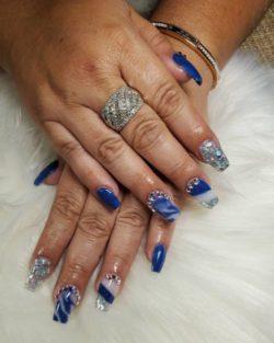 Uñas largas azules con blanco y muchas perlas
