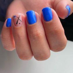 Uñas cortas azules con una uña sin pintar y detalles