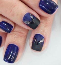 Uñas cortas en azul oscuro decoradas con plata