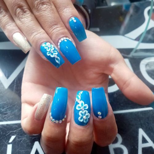 Uñas largas celestes con relieve de flores blancas y perlas