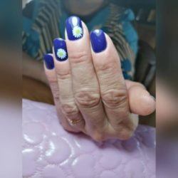 Uñas cortas en azul oscuro con margaritas