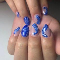 Uñas transparentes con azul y vetas blancas