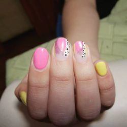 Uñas cortas rosas con brillos y lunares negros sobre blanco