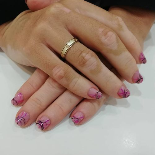Uñas rosas brillantes con dibujos circulares