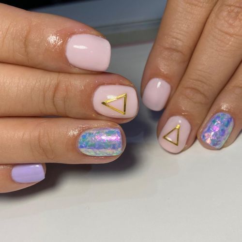Uñas cortas rosas y lilas con triángulos dorados