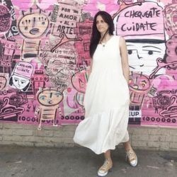 Mujer con vestido largo blanco y zapatillas color crema