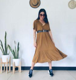 Mujer con vestido largo marrón y nike azules