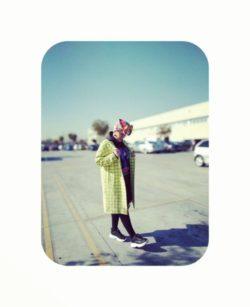 Mujer con abrigo largo y zapatillas y pañuelo en la cabeza