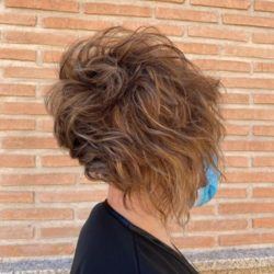 Corte de pelo rizado corto asimétrico