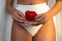 Mujer con flor roja en copa menstrual