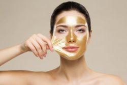 Mujer con mascarilla facial de oro