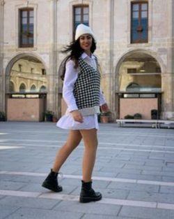 Chaleco de punto con falda blanca y camisa blanca